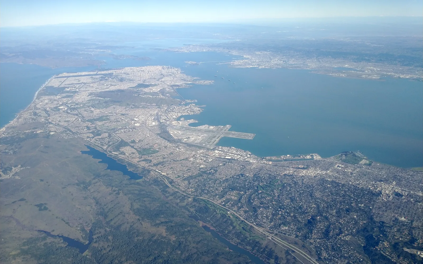 Aerial view of northern San Mateo County showing the peninsula landscape between San Francisco and the South Bay, with residential and commercial development